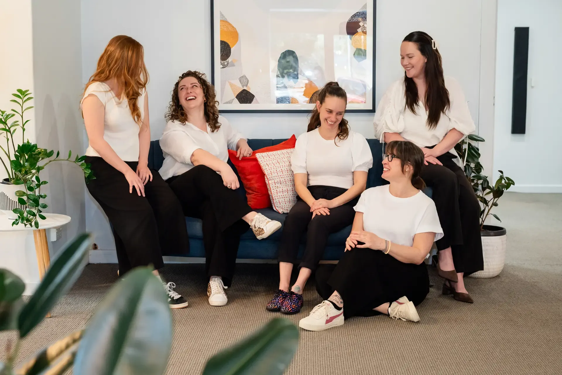 The Chiro Crew team laughing together on the lounge at The Chiro Crew in Kingswood